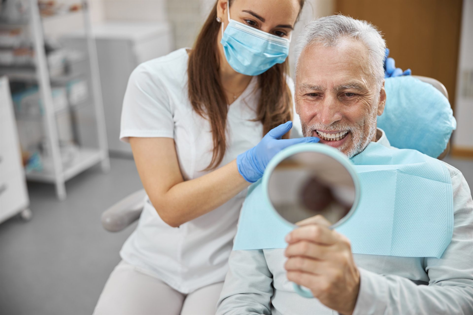 Happy dental implant patient reviewing his new smile at Nova Implant & Perio Specialists